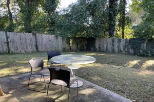 3 Stühle und ein Glastisch im Hof in der Unterkunft Stone Mountain's Hidden Secret in Stone Mountain