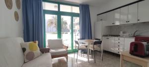 a living room with a kitchen and a table with chairs at DALIUS HOME - Apartment with pool near the dunes of Maspalomas in Playa del Ingles