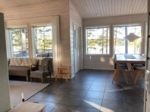 a living room with a table and chairs and windows at Puikkari Raijan Aitta in Mikkeli