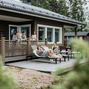 un grupo de personas sentadas en la cubierta de una casa en Puikkari Raijan Aitta, en Mikkeli