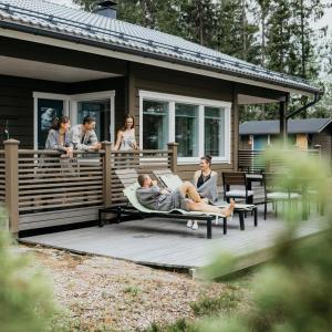 a group of people sitting on the deck of a house at Puikkari Raijan Aitta in Mikkeli