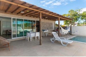 un patio con mesa, sillas y piscina en Casa Malie - Barra Grande, en Vitória de Santo Antão