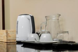 a coffee maker and two cups on a table at Pahotela Bed and Breakfast in Palatswe