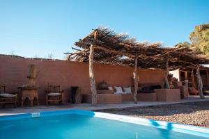 un complejo con piscina frente a una casa en Hotel Pat'ta Hoiri en San Pedro de Atacama