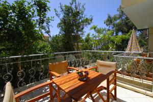 a wooden table and chairs on a balcony at Afrodite Hotel Apartments in Myrina