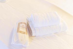 biały ręcznik i rolka papieru toaletowego na łóżku w obiekcie Castello di Haria w mieście Kaloú +37 zdjęć
