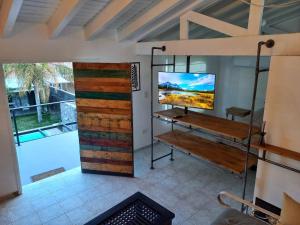 Habitación con TV en la pared y puerta de madera. en H125 - Complejo Mendoza en Mendoza