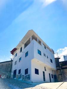 un bâtiment blanc à côté d'une étendue d'eau dans l'établissement Hotel Posada Sernichari, à Cuetzalán del Progreso