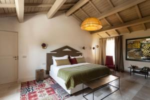 a bedroom with a large bed and a chandelier at Palazzo Maresgallo Suites & SPA in Lecce