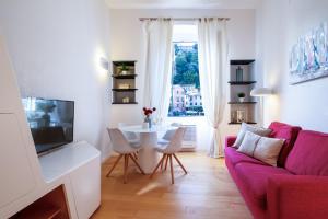 sala de estar con sofá rosa y mesa en Wanderlust by PortofinoHomes en Portofino