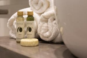 two bottles of soap and towels on a counter at Wanderlust by PortofinoHomes in Portofino