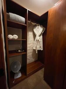 - un dressing avec une chemise et un ventilateur dans l'établissement Suítes - Casa Jardim Chapada, à Alto Paraíso de Goiás