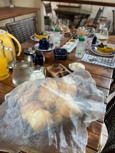 uma mesa de madeira com comida em cima em Suítes - Casa Jardim Chapada em Alto Paraíso de Goiás