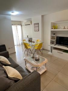 uma sala de estar com um sofá e uma mesa em Departamento en pleno centro en complejo con Pileta y Gimnasio em Córdoba