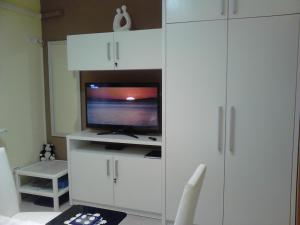 a living room with a tv and white cabinets at Room Sarah in Rijeka