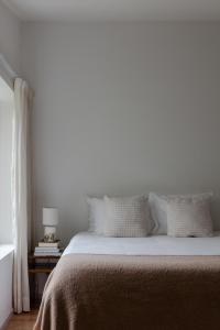 a bedroom with a bed and a table with a lamp at A Padaria Farmhouse in Cinfães