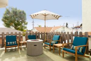 a group of chairs and an umbrella on a patio at Sonrisa I by AvantStay Bright Pacific Beach Home in San Diego