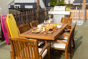 a wooden table with plates of food on a patio at Sonrisa I by AvantStay Bright Pacific Beach Home in San Diego