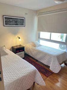 2 camas num quarto com uma janela em Departamento en pleno centro en complejo con Pileta y Gimnasio em Córdoba