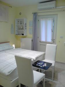 a bedroom with a bed and two chairs and a table at Room Sarah in Rijeka