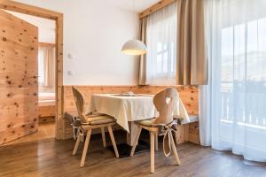 - une salle à manger avec une table et deux chaises dans l'établissement Superior Apartment Marialisa Tulpe, à Chiusa