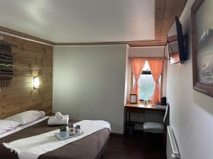 プエルト・バラスにある7 Arriendo Habitación doble con Baño Privado de Ex Hotelのベッド2台、デスク、窓が備わる客室です。