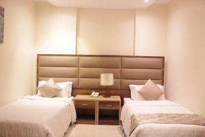 a bedroom with two beds and a table with a lamp at التميز الراقي - السليمانية in Jeddah