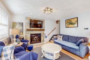 sala de estar con sofás azules y chimenea en Victory Cottage at NH, en Moultonborough