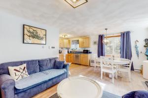 sala de estar con sofá azul y mesa en Victory Cottage at NH, en Moultonborough
