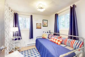 1 dormitorio con cortinas azules y 1 cama en Victory Cottage at NH, en Moultonborough