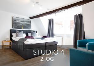 a bedroom with a bed and a blue chair at Townhouse Duderstadt in Duderstadt