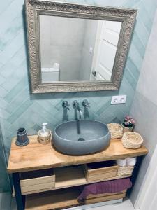 a bathroom sink with a mirror on top of it at La casita de San Andrés in Seville
