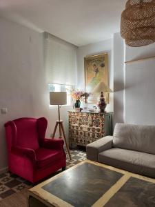 a living room with a couch and a red chair at La casita de San Andrés in Seville