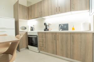 a kitchen with wooden cabinets and a sink at Comfy Sweet Home in Athens