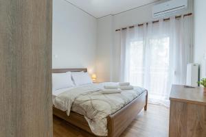 Comfy Sweet Home في أثينا: غرفة نوم بسرير ونافذة كبيرة