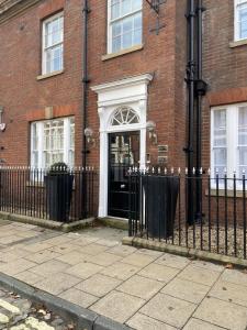 a black fence in front of a brick building with a door at 10 Bootham House - luxury city centre apartment with free parking for one car in York