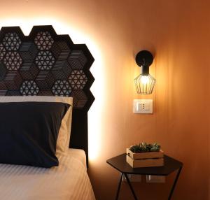 um quarto com uma cama e uma mesa com um candeeiro em Liotru Maisonne em Catânia