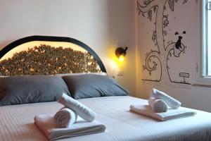 a bedroom with a bed with towels on it at Liotru Maisonne, rooms with en-suite bathroom and shared bathroom in Catania