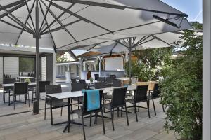 a patio with tables and chairs under an umbrella at Hotel Lenz in Fulda