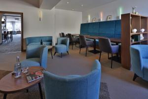 a waiting room with blue chairs and a table at City Partner Hotel Lenz in Fulda