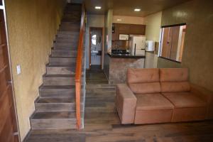 a living room with a couch and a staircase at Chalé Ubajara in Ubajara