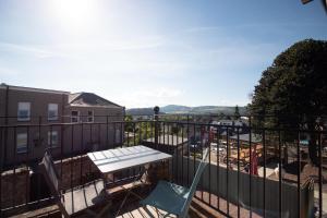 Un balcón con una mesa y sillas en un balcón. en Gordonston Apartments, en Inverness