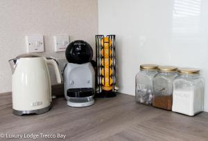 a coffee maker sitting on a counter next to jars of food at Holiday Lodge 6 in Porthcawl
