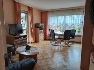 sala de estar con mesa, sillas y TV en Wohnen wie bei Freunden, en Braunlage