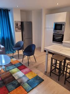 a room with a kitchen with a table and chairs at APPART Maasso CITE DESIGN in Saint-Étienne