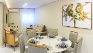 a dining room with a white table and chairs at Apartamento completo - Vila A in Foz do Iguaçu