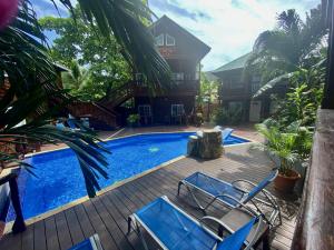 a patio with chairs and a swimming pool at The Blue Bahia Resort In Sandy Bay in Coxen Hole