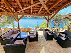 eine Terrasse mit Stühlen und Tischen und Blick auf das Wasser in der Unterkunft Villa Jagodna in Hvar