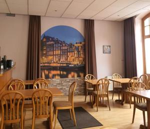 a restaurant with tables and chairs and a large window at Gasthaus Pension DÖRENKRUG - Restaurant in Augustdorf