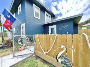 Una casa con una cerca con un pavo. en La Buena Pescada - Aransas Pass, TX Coastal Cottage!, en Aransas Pass
